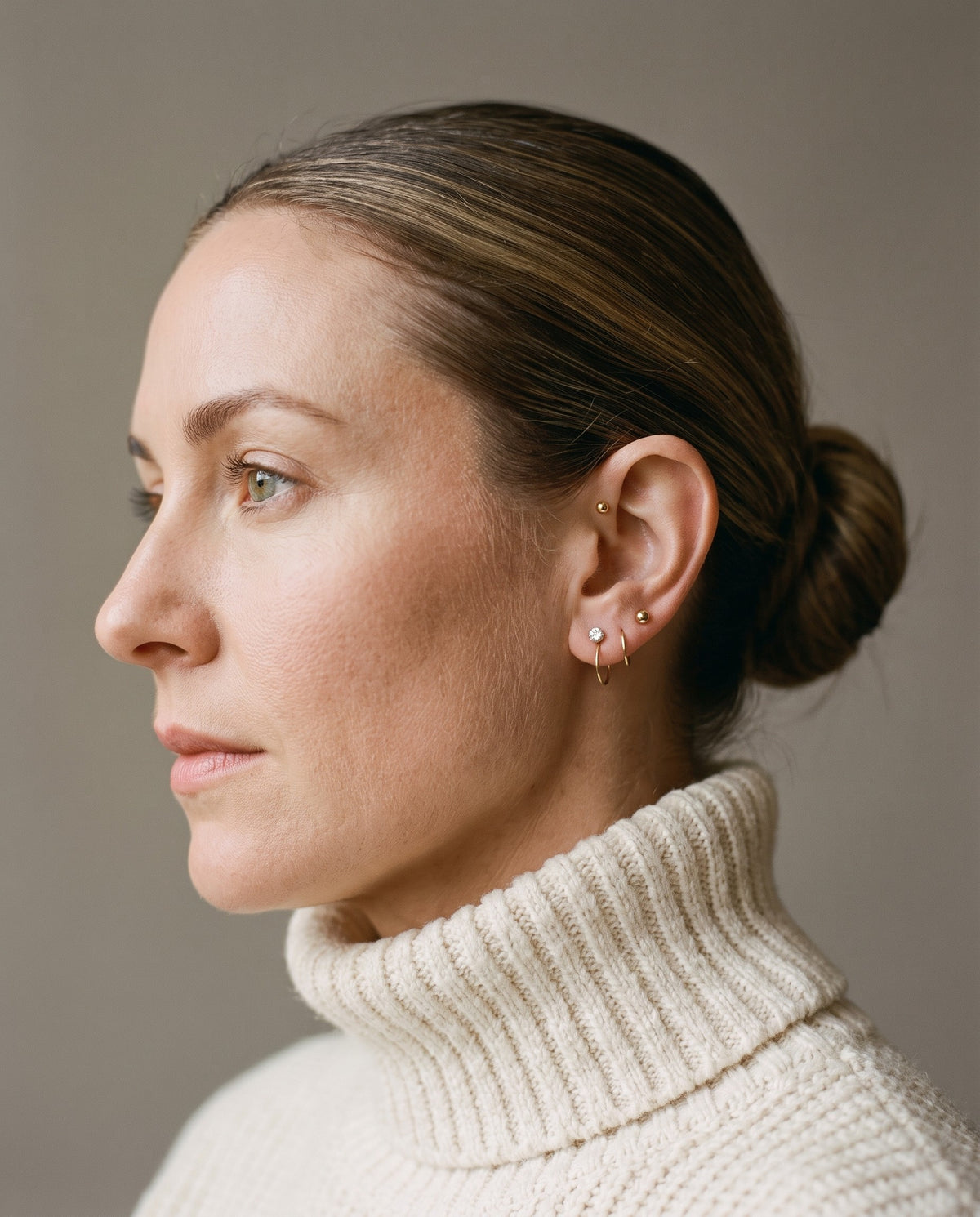Clear Round Open Hoop and Ball Open Hoop in 18K Gold Vermeil on an ear in profile, above a cream knit collar.