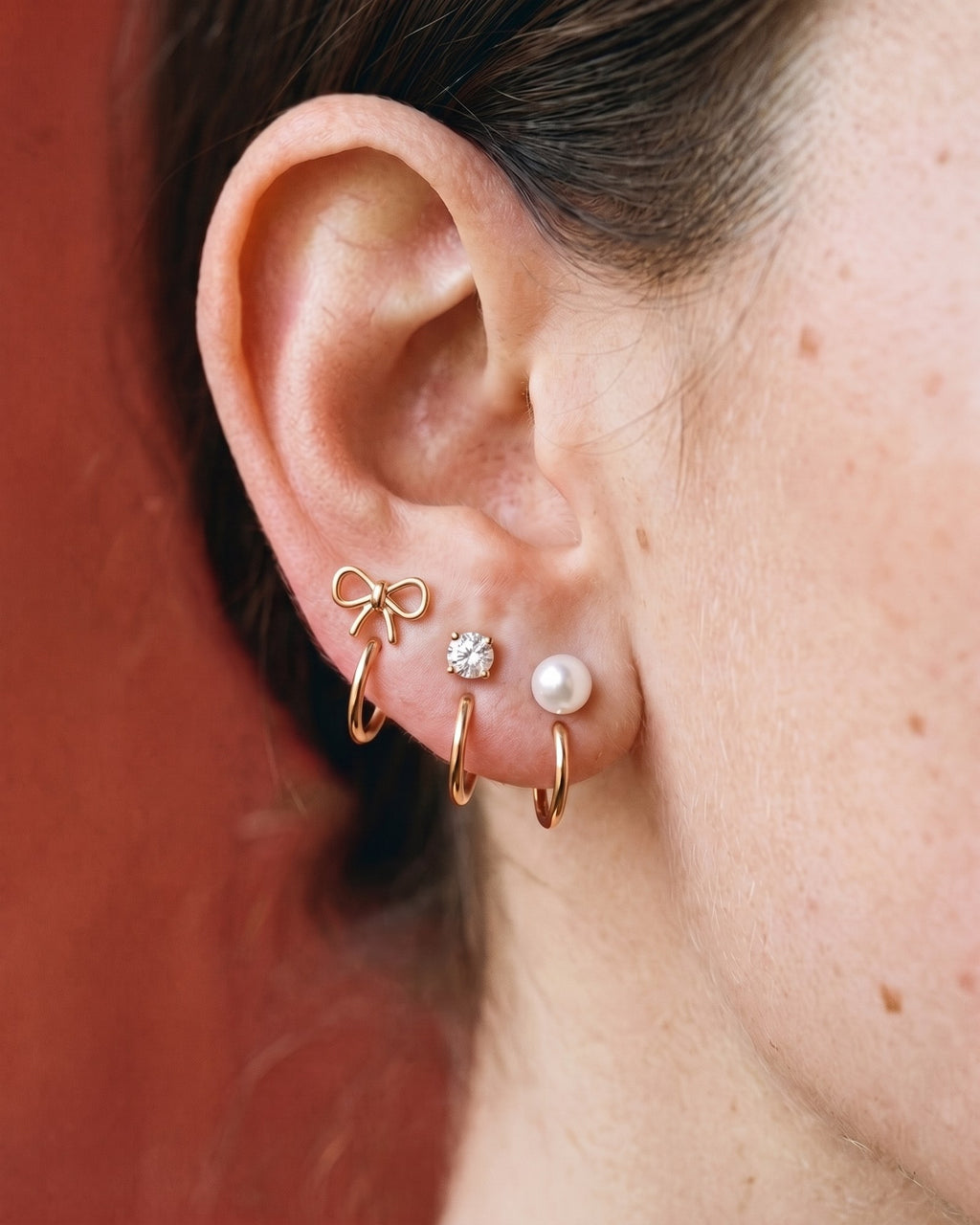 The Bow, Clear Round and White Bead set in 18K Rose Gold Vermeil, worn on one ear