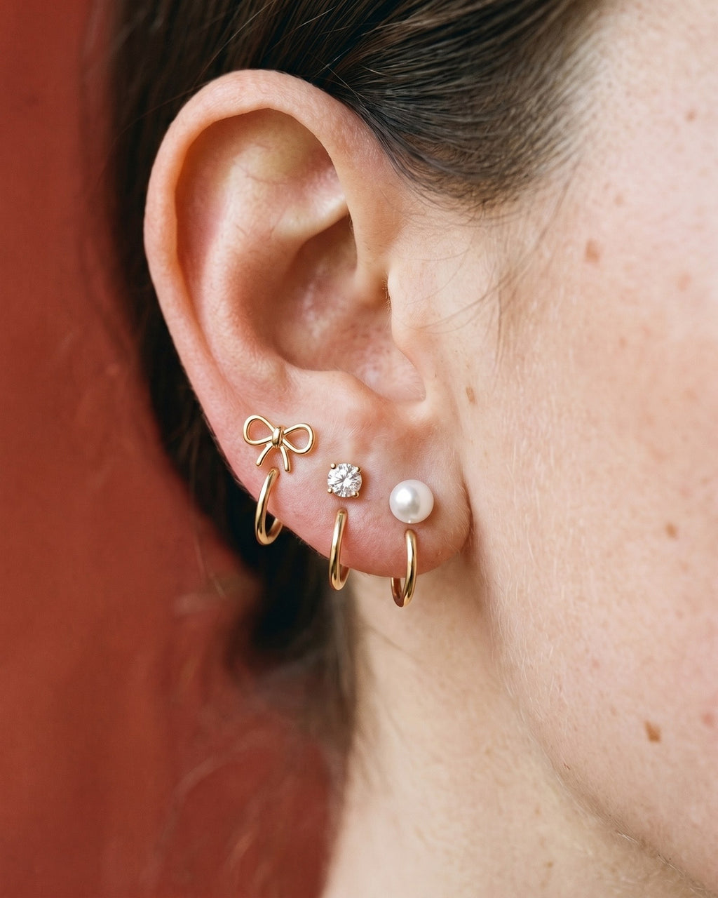 The Bow, Clear Round and White Bead set in 18K Gold Vermeil, worn on one ear