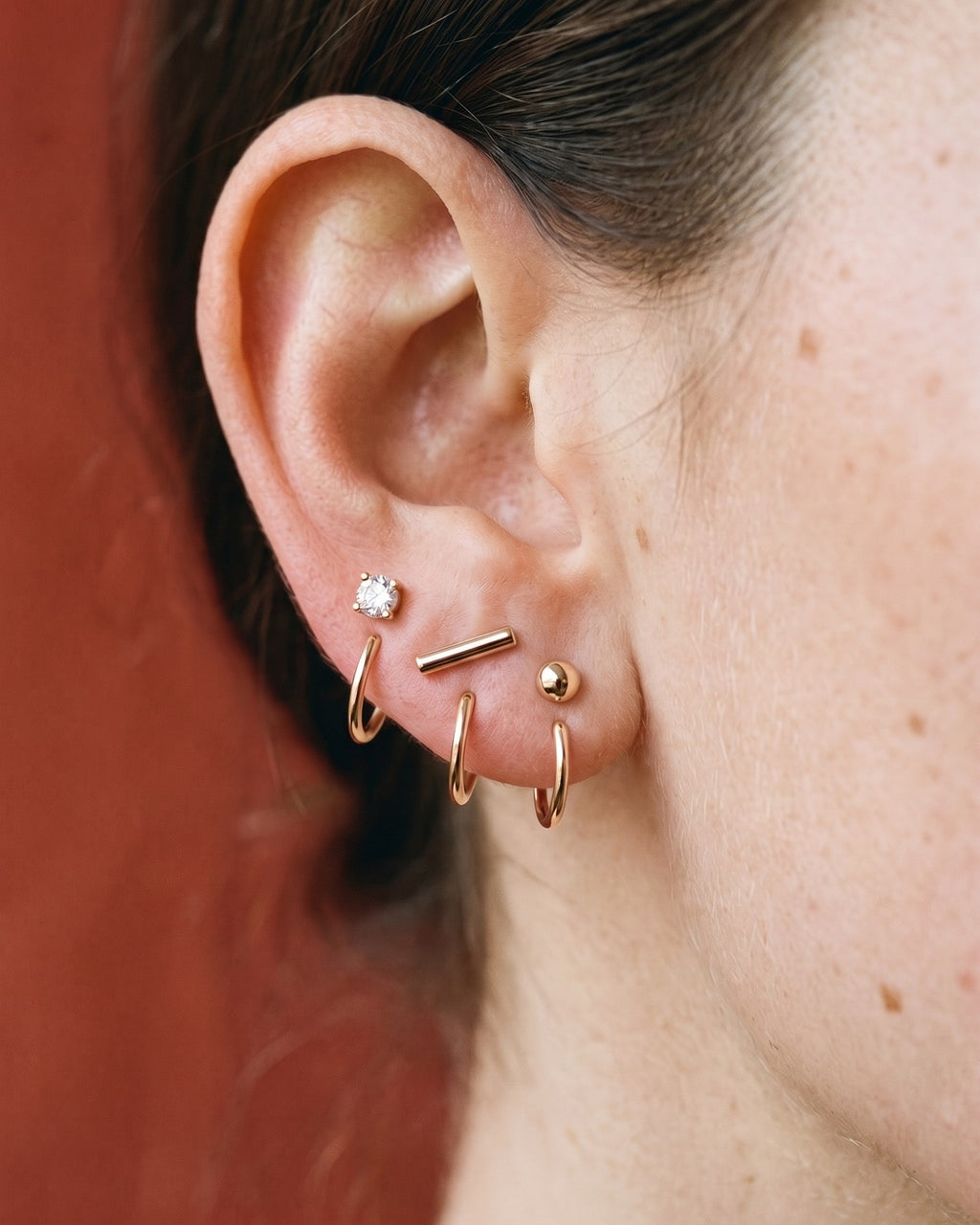 The Clear Round, Bar and Ball set in 18K Rose Gold Vermeil, worn on one ear