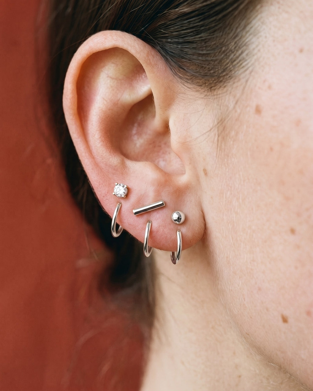 The Clear Round, Bar and Ball set in Sterling Silver, worn on one ear