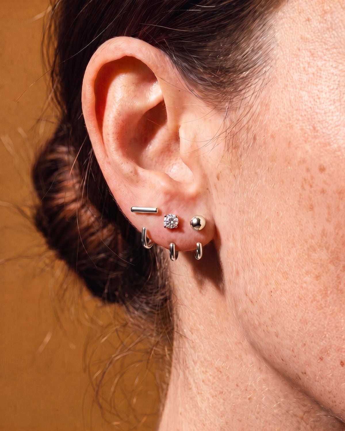 The Clear Round, Bar and Ball set in Sterling Silver, worn on one ear