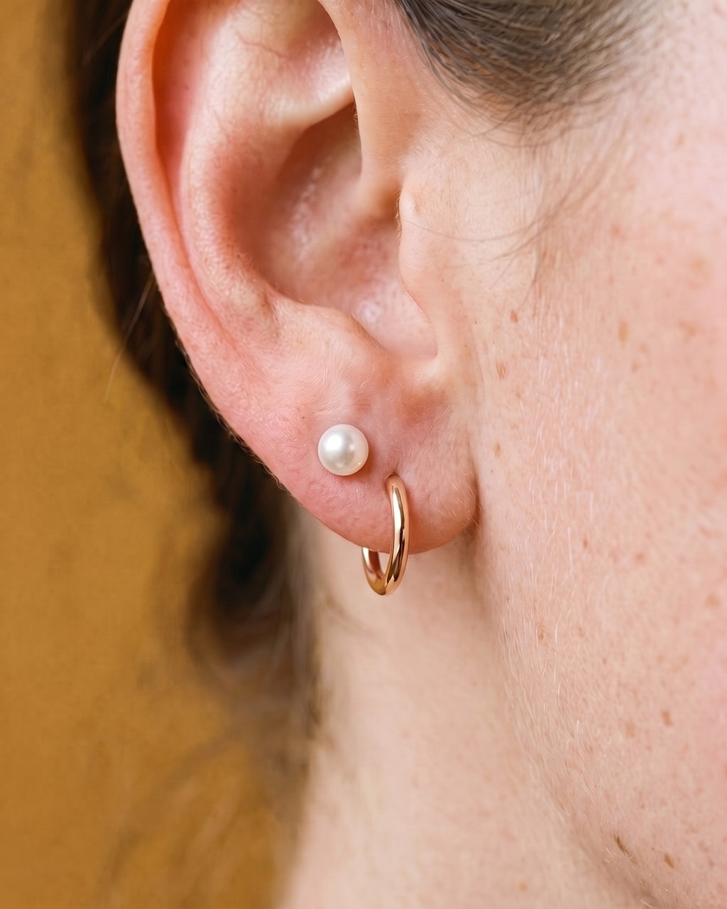 White Bead Open Hoop in 18K Rose Gold Vermeil, worn on the ear